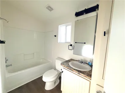 a bathroom with a granite countertop toilet sink and mirror