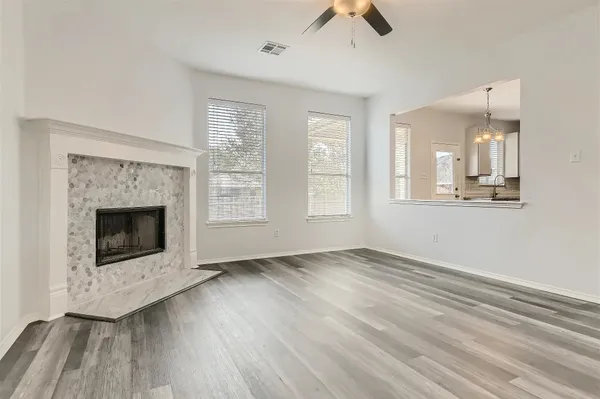 an empty room with windows and fireplace
