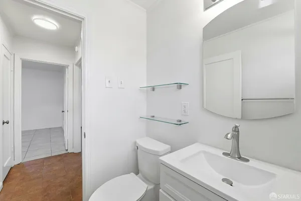 a bathroom with a sink mirror vanity and toilet