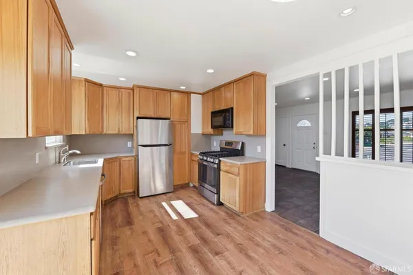 a kitchen with refrigerator cabinets and wooden floor