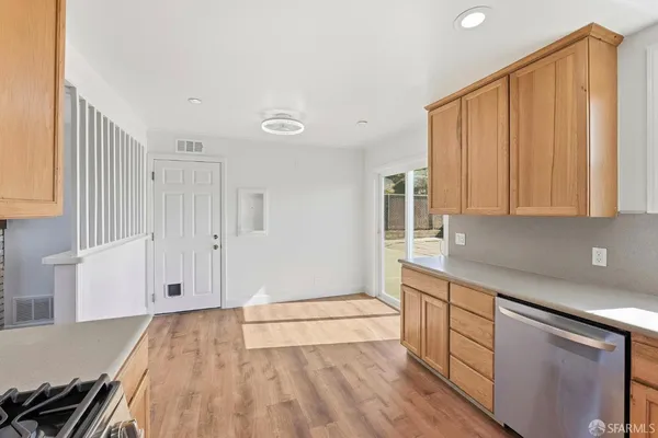 a view of a kitchen with wooden floor and cabinets