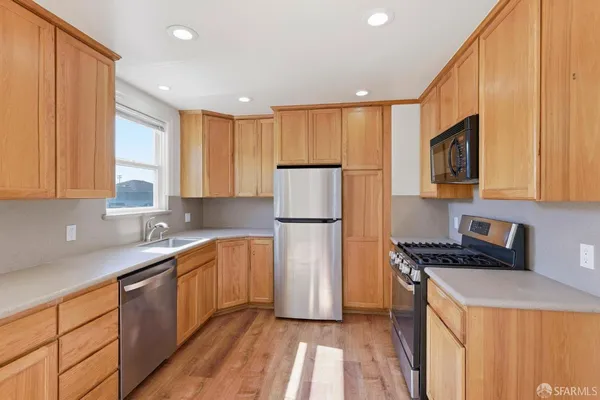a kitchen with a sink a refrigerator a stove a microwave and cabinets