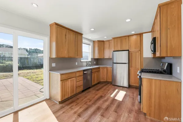 a kitchen with sink a refrigerator and wooden cabinets