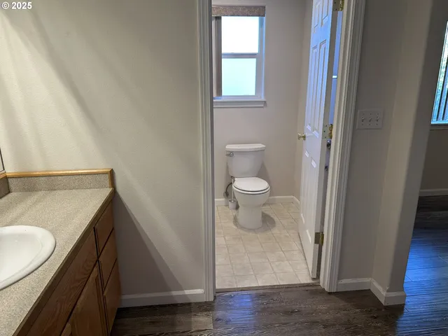 a bathroom with a granite countertop sink toilet and vanity