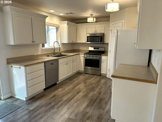 a kitchen with stainless steel appliances a refrigerator sink and microwave