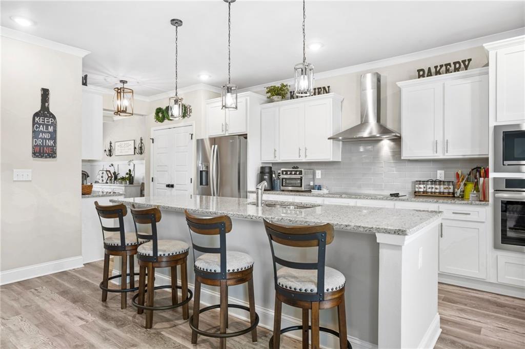 2326 Britt Street Grayson, GA 30017 - Photo 14 of 53 a kitchen with stainless steel appliances kitchen island granite countertop a table chairs and a refrigerator