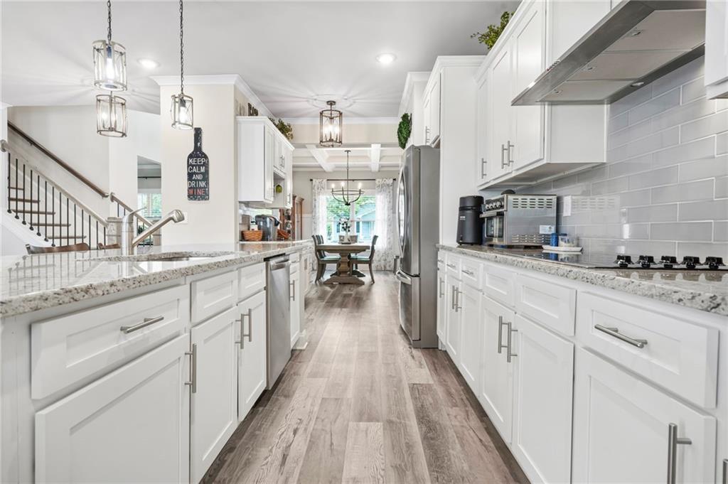 2326 Britt Street Grayson, GA 30017 - Photo 17 of 53 a large white kitchen with granite countertop lots of counter space wooden floor and stainless steel appliances