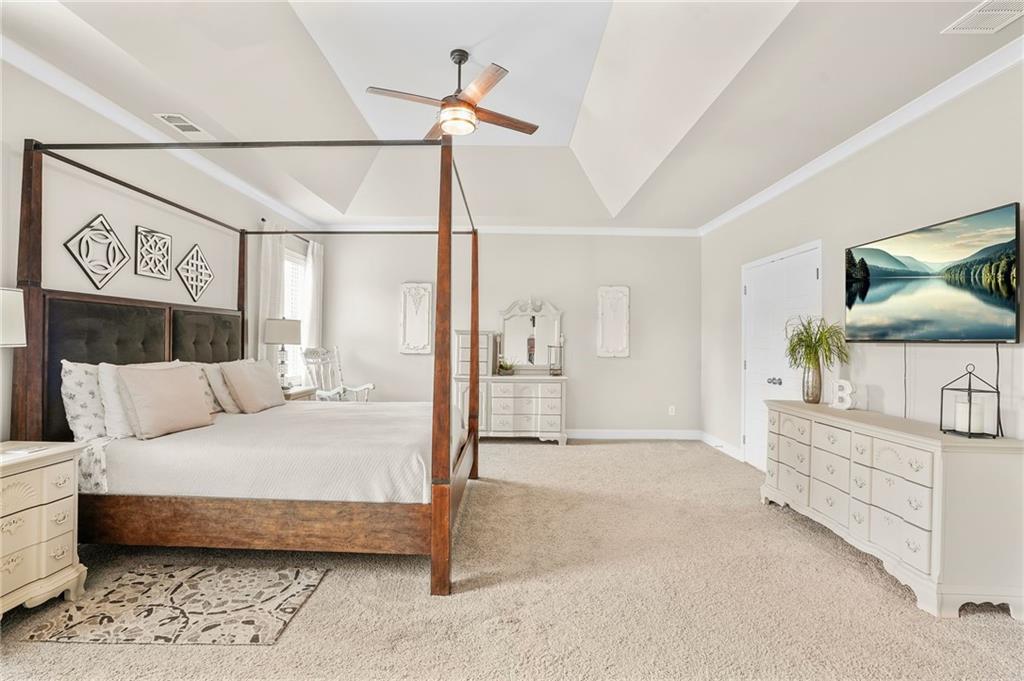 2326 Britt Street Grayson, GA 30017 - Photo 28 of 53 a bedroom with a large bed and a chandelier