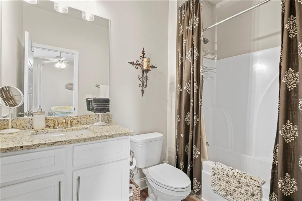 2326 Britt Street Grayson, GA 30017 - Photo 46 of 53 a bathroom with a granite countertop sink a toilet a mirror and shower