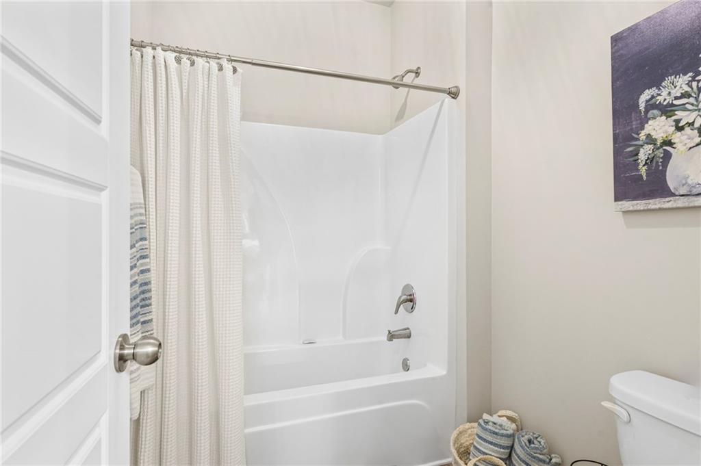 2326 Britt Street Grayson, GA 30017 - Photo 47 of 53 a bathroom with a shower curtain and a toilet