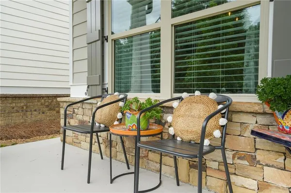 a patio with table and chairs and potted plants