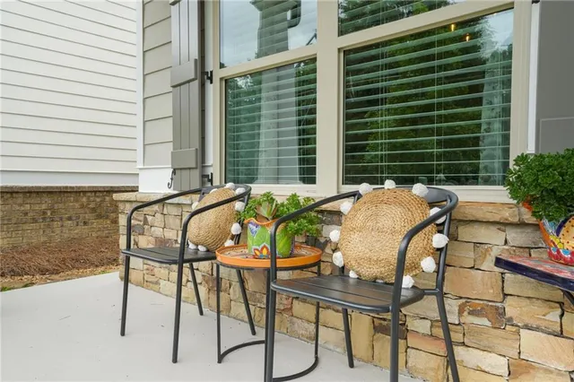a patio with table and chairs and potted plants