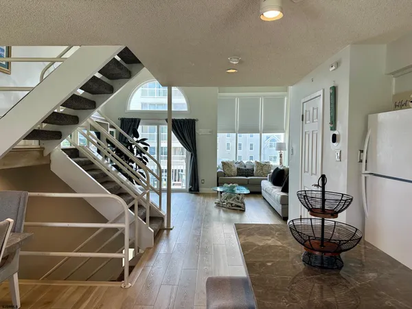 a kitchen with stainless steel appliances sink refrigerator dining table and chairs
