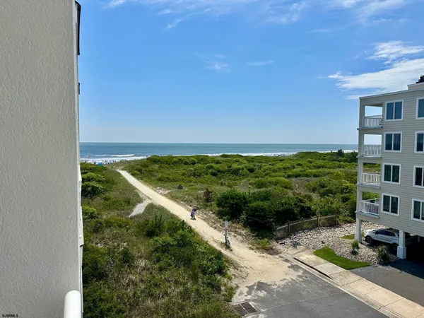 a kitchen with a refrigerator a stove a sink and white cabinets with wooden floor