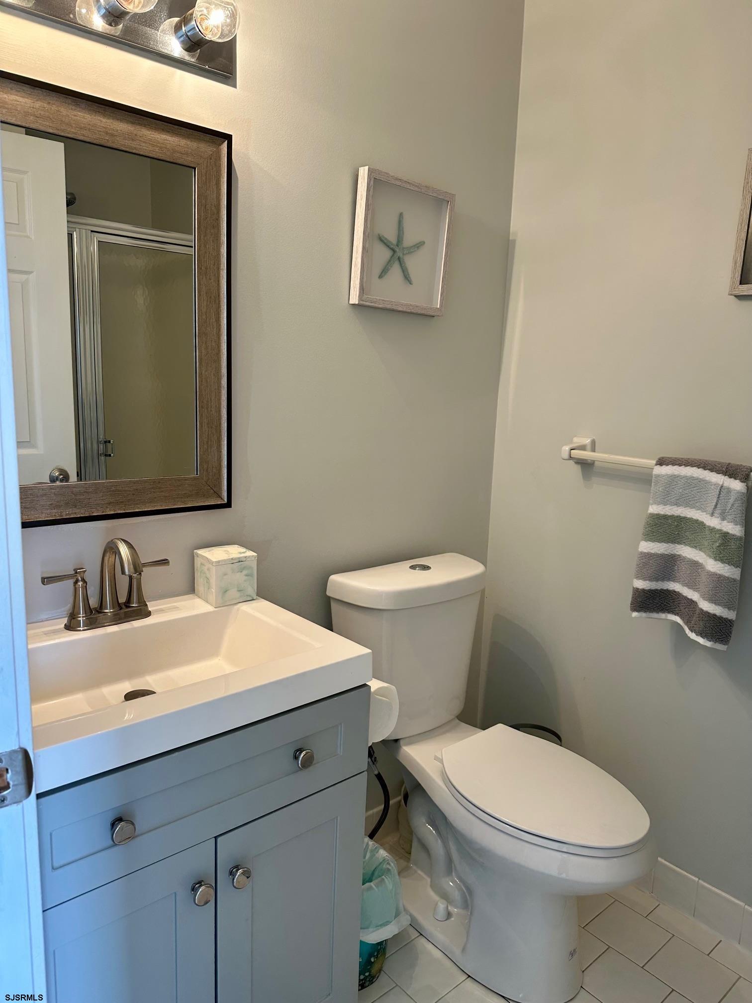 305 4th Street South, Unit 305 Brigantine, NJ 08203 - Photo 7 of 45 a bathroom with a toilet a sink and mirror