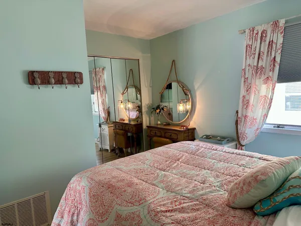 a bedroom with a bed a mirror and dresser