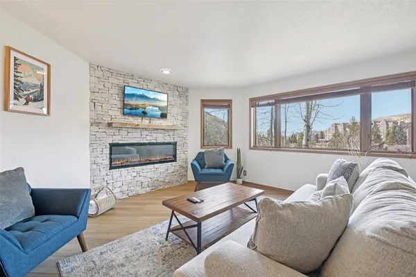 a living room with furniture a flat screen tv and a fireplace