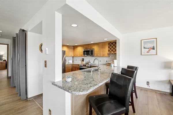 a kitchen with granite countertop kitchen island stainless steel appliances a refrigerator and a counter top space