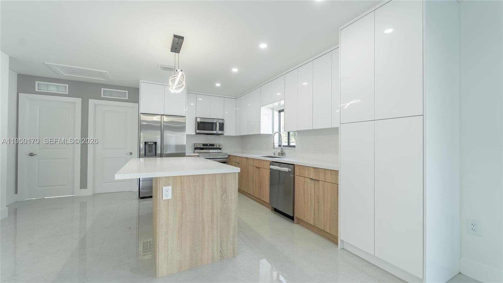 22840 Southwest 122nd Place Miami, FL 33170 - Photo 16 of 36 a kitchen with kitchen island a sink stainless steel appliances and cabinets