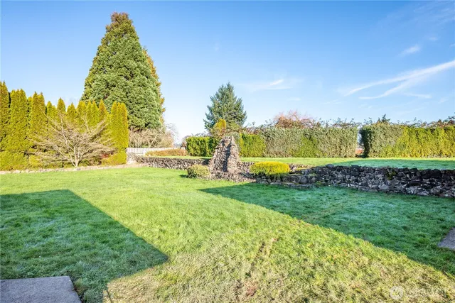a yard with lots of green space and building in the back