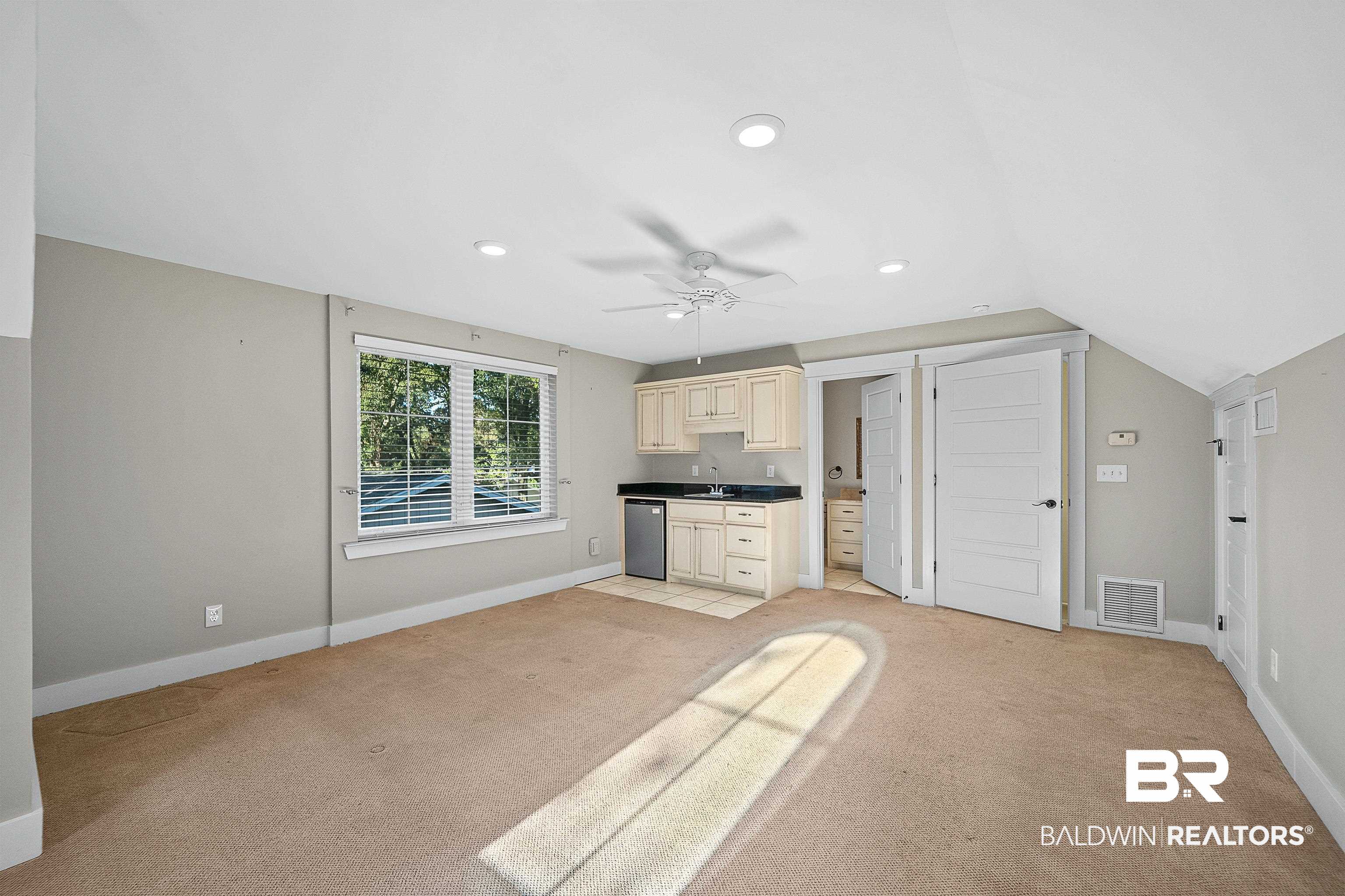 356 Liberty Street Fairhope, AL 36532 - Photo 26 of 39 Kitchen with light carpet, dark countertops, recessed lighting, stainless steel dishwasher, and cream cabinets