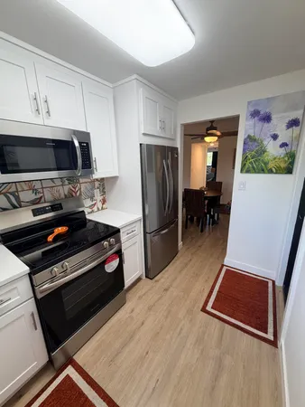 a kitchen with granite countertop a refrigerator stove and microwave