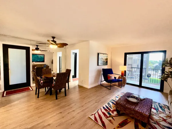 a living room with furniture a wooden floor and next to a window