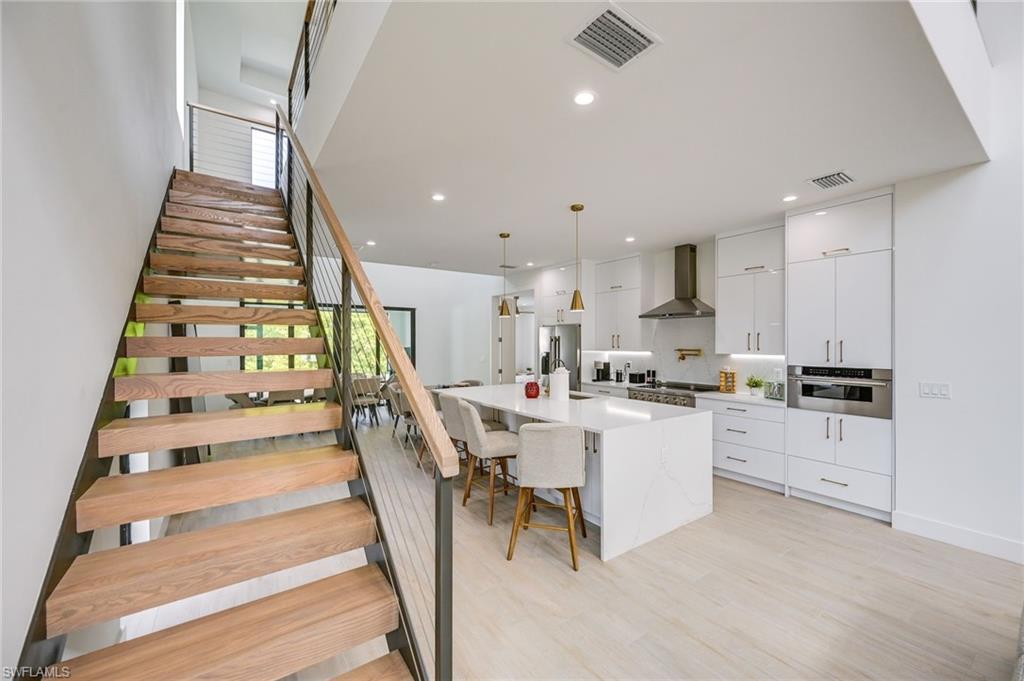 3400 Canal Street Naples, FL 34112 - Photo 11 of 34 a kitchen with white cabinets and white appliances