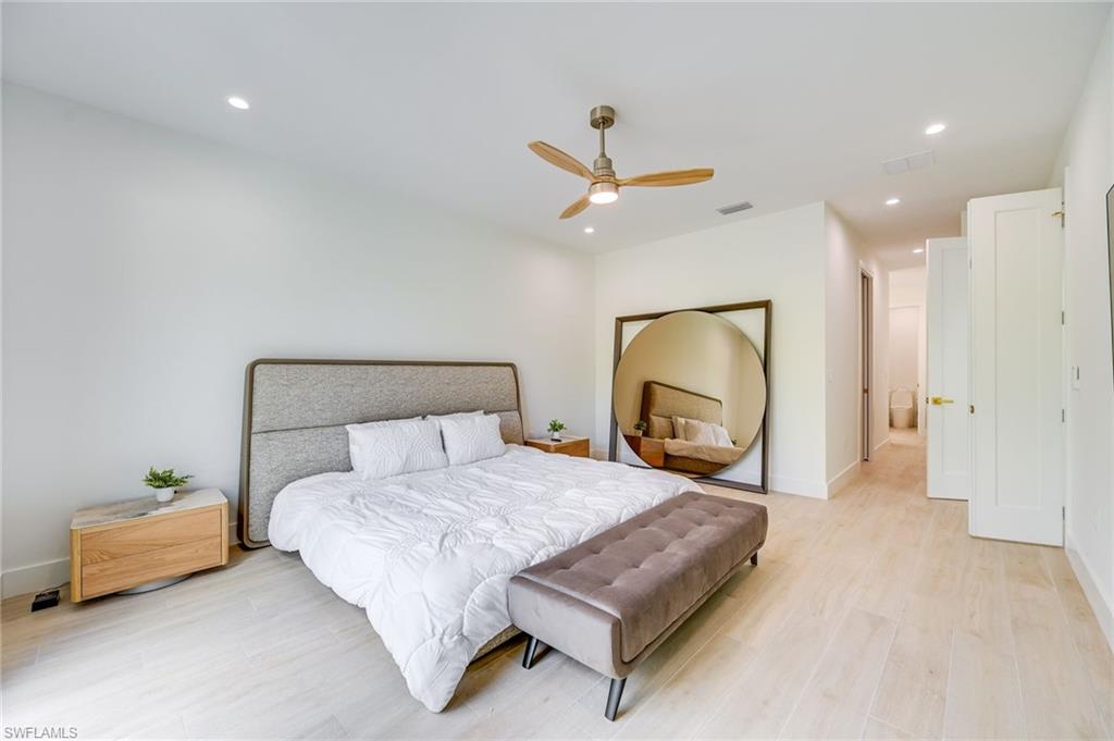 3400 Canal Street Naples, FL 34112 - Photo 15 of 34 a bedroom with a bed a mirror and a potted plant