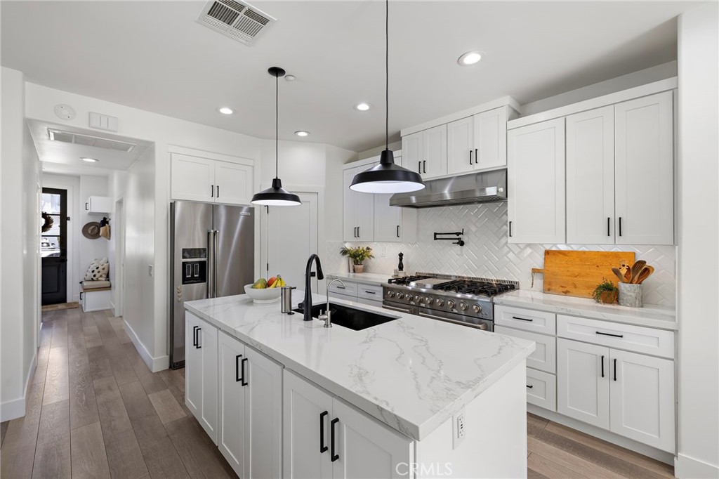 7 Bluewing Lane Ladera Ranch, CA 92694 - Photo 9 of 55 a kitchen with white cabinets and stainless steel appliances