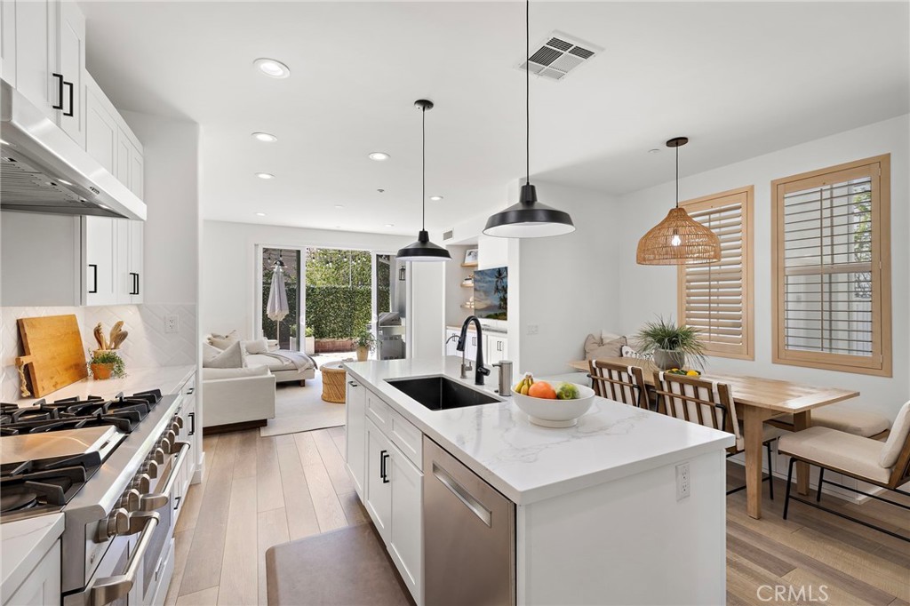 7 Bluewing Lane Ladera Ranch, CA 92694 - Photo 10 of 55 a kitchen with a stove a sink a kitchen island a dining table and chairs