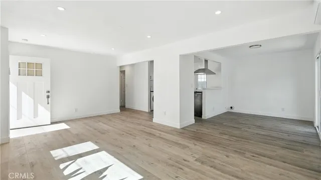 a view of empty room with wooden floor and entryway