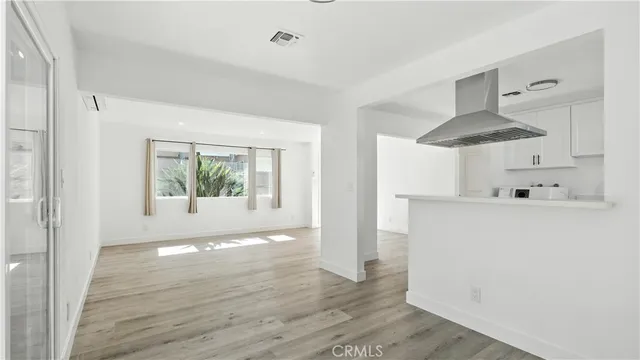 a view of hallway with wooden floor and cabinets