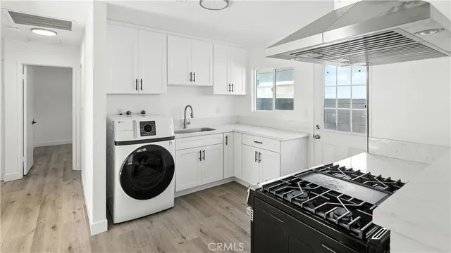 a kitchen with a stove and white cabinets