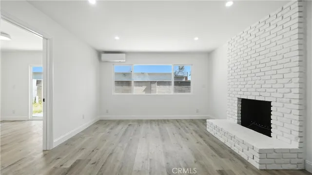 a view of empty room with wooden floor and fireplace