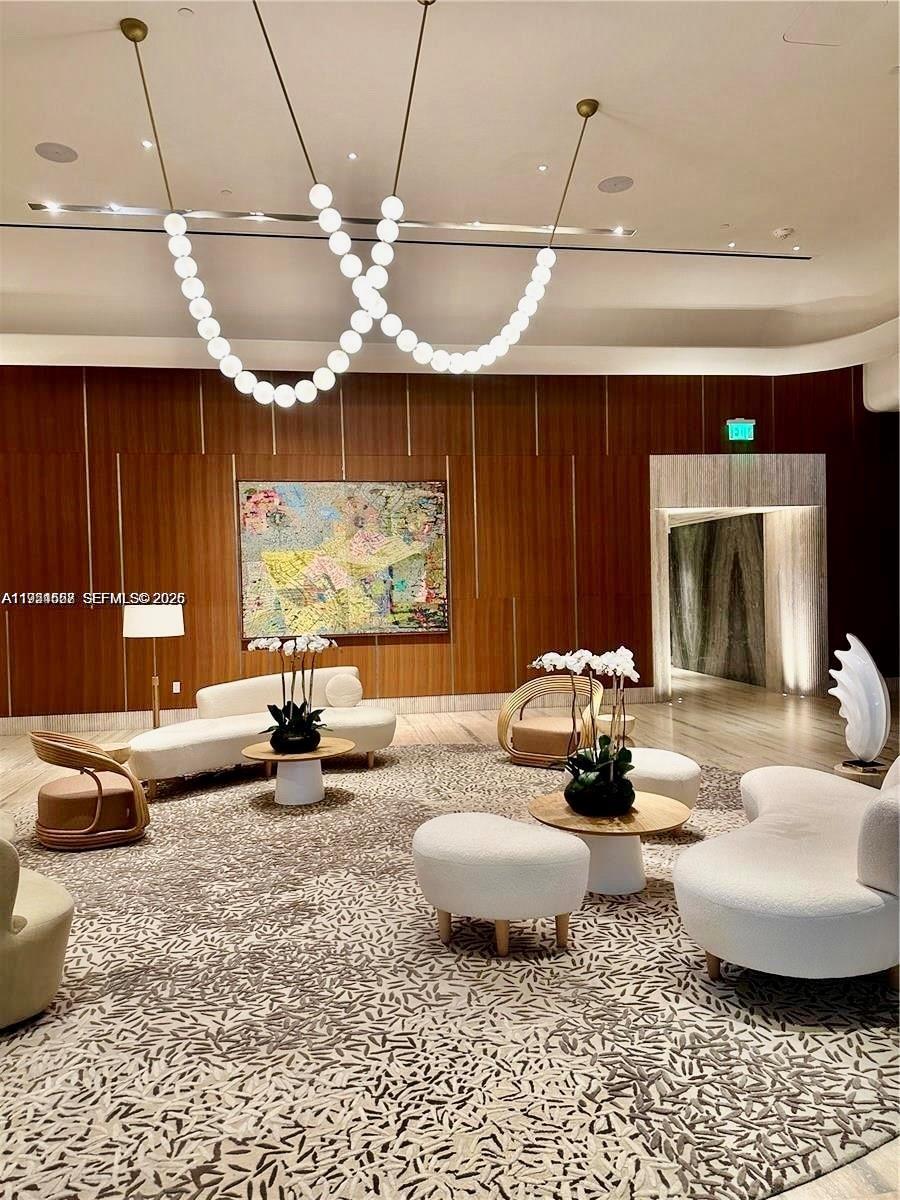 500 Alton Road, Unit 1208 Miami Beach, FL 33139 - Photo 3 of 16 a living room with furniture a chandelier and a large window