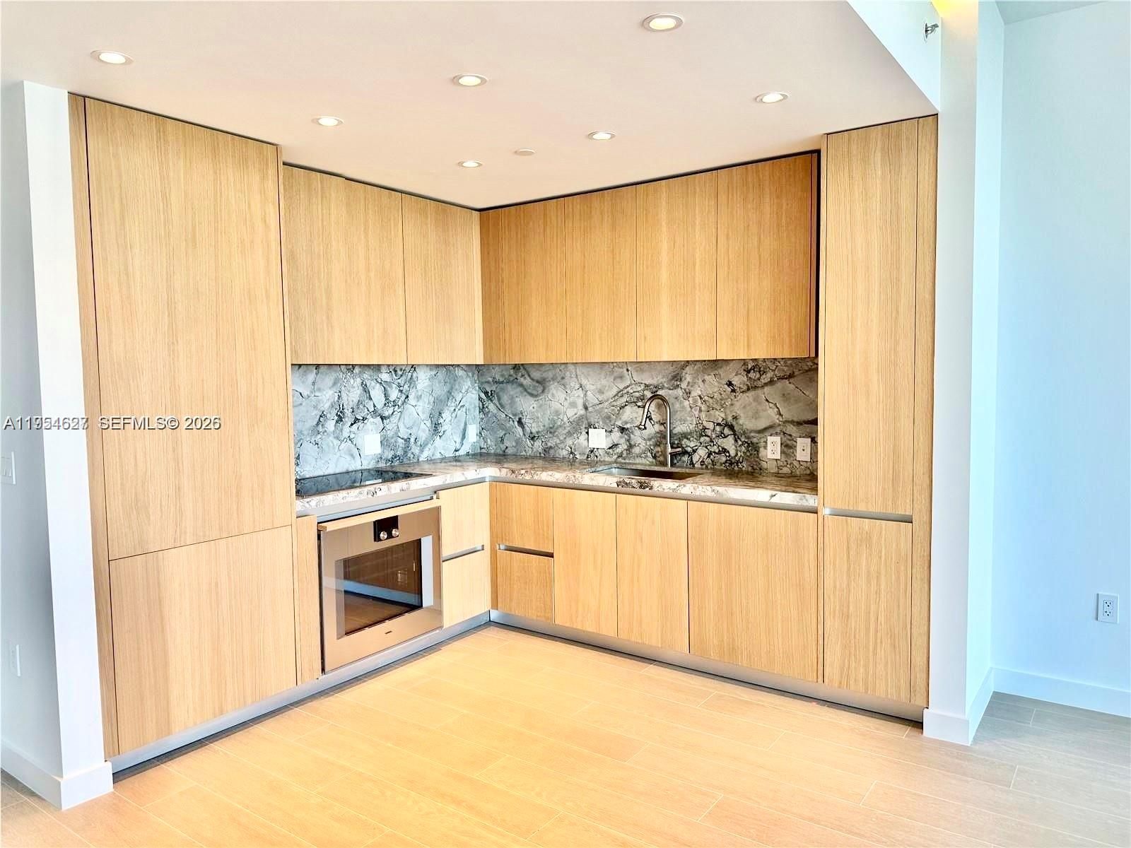 500 Alton Road, Unit 1208 Miami Beach, FL 33139 - Photo 9 of 16 a view of a kitchen with stainless steel appliances granite countertop a stove a sink and a refrigerator with cabinets
