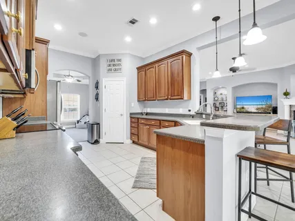 a kitchen with stainless steel appliances granite countertop a stove a sink a refrigerator and a microwave