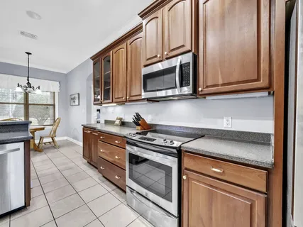 an empty room with chandelier fan and windows