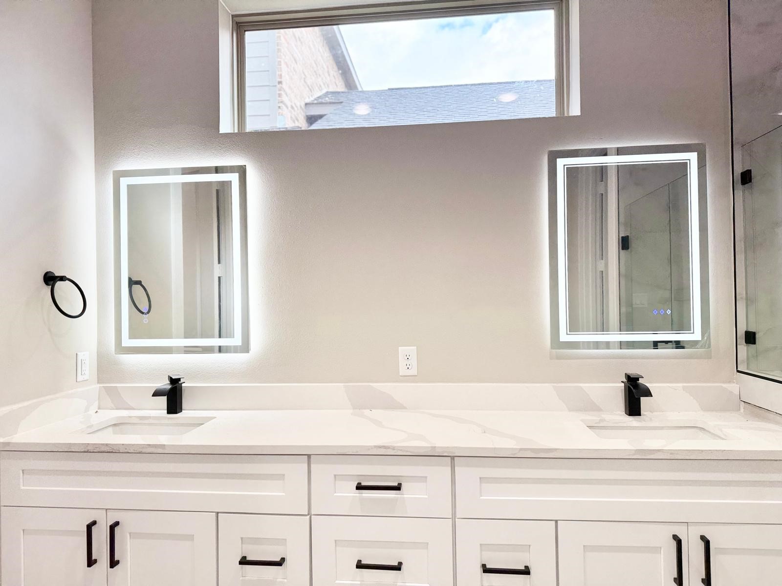 2518 Liguria Ln Spring Spring, TX 77388 - Photo 14 of 36 Luxurious primary bathroom featuring a modern double vanity with sleek fixtures and LED-lit mirrors, offering both style and functionality.
