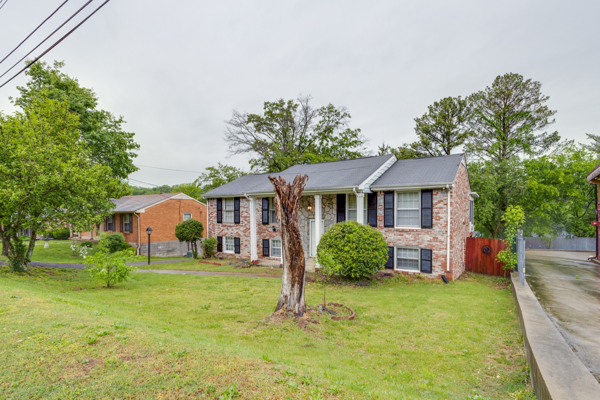 76 Tusculum Road Antioch, TN 37013 - Photo 3 of 33 a front view of a house with a garden and trees
