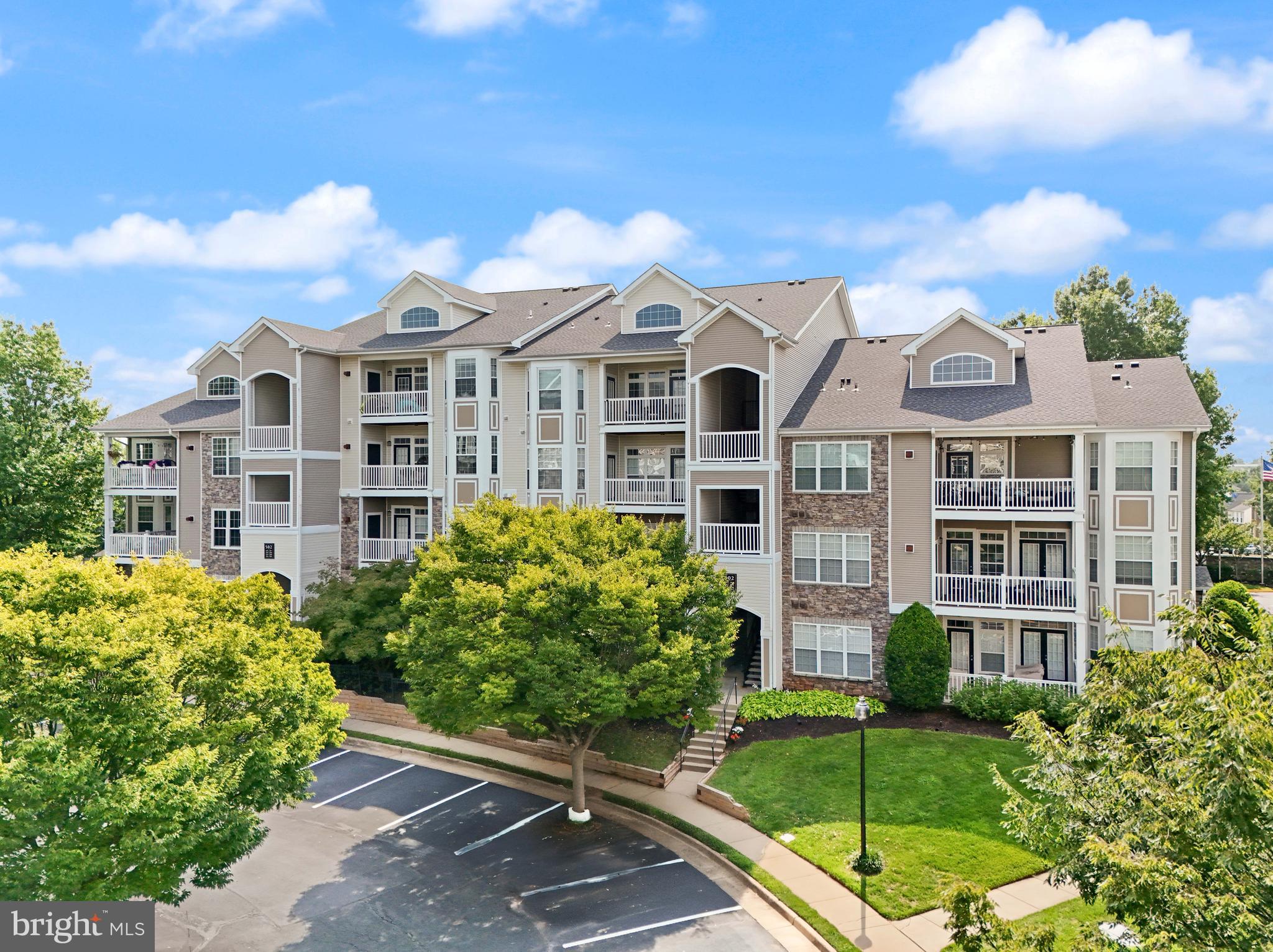 502 Sunset View Terrace Southeast, Unit 107 Leesburg, VA 20175 - Photo 1 of 50 a front view of a residential apartment building with a yard