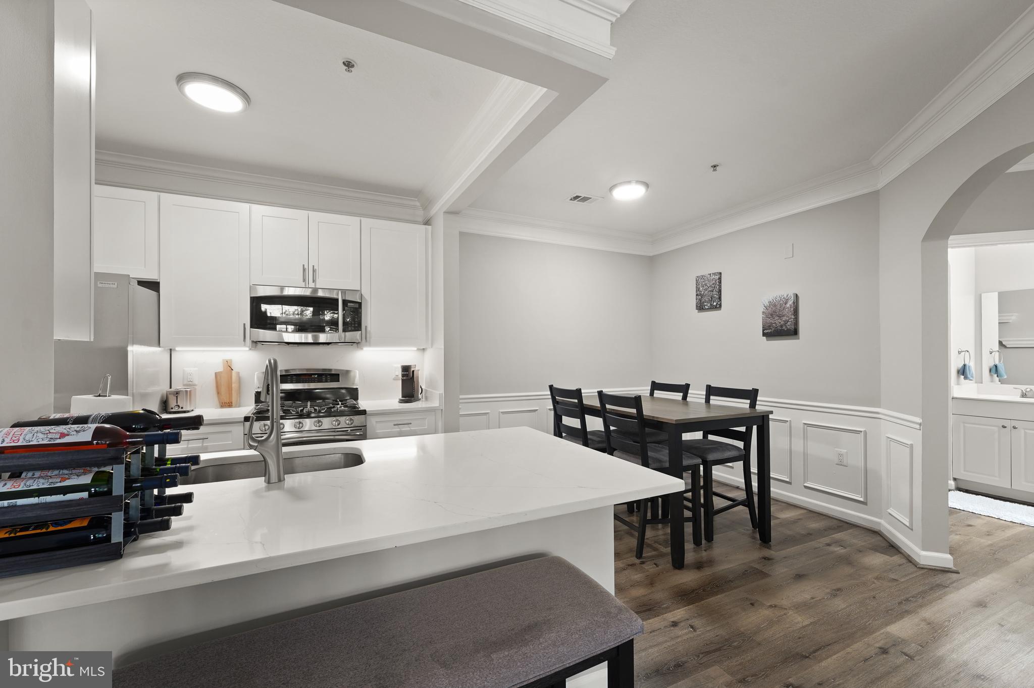 502 Sunset View Terrace Southeast, Unit 107 Leesburg, VA 20175 - Photo 17 of 50 a kitchen with appliances a table chairs and a refrigerator
