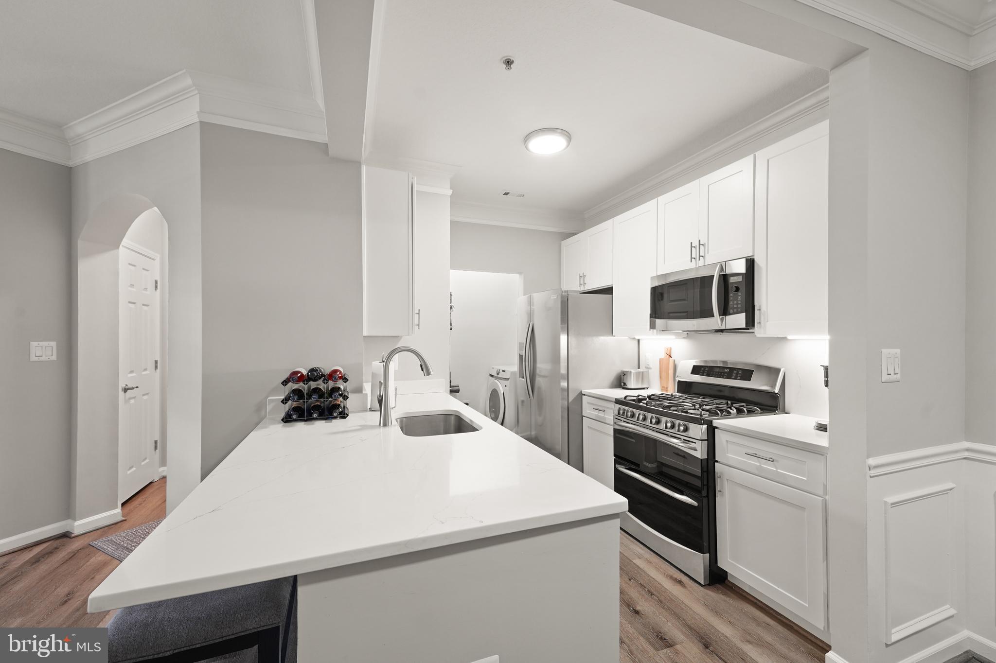 502 Sunset View Terrace Southeast, Unit 107 Leesburg, VA 20175 - Photo 21 of 50 a kitchen with a sink a stove and white cabinets