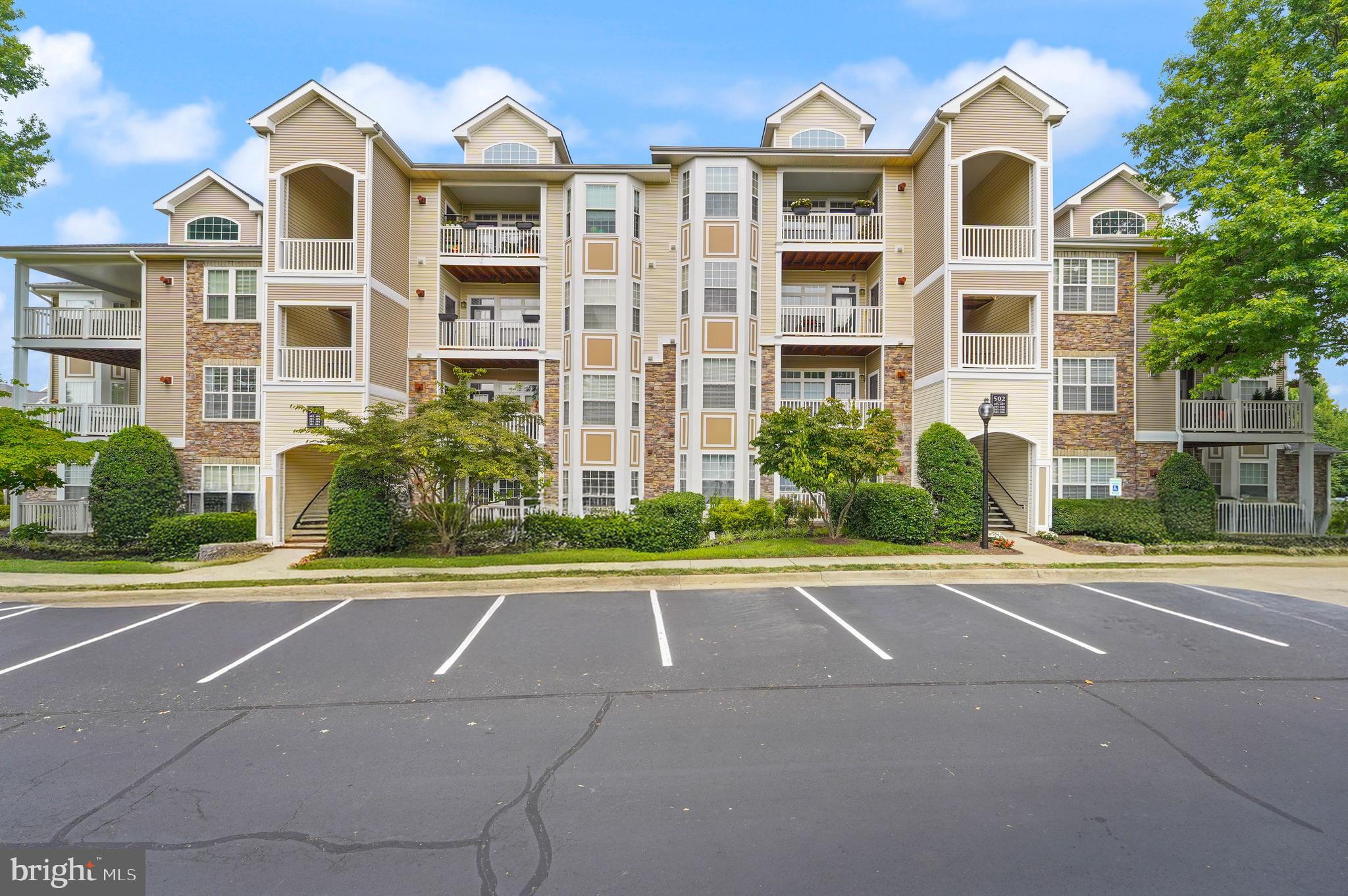 502 Sunset View Terrace Southeast, Unit 107 Leesburg, VA 20175 - Photo 4 of 50 front view of a brick house with a yard