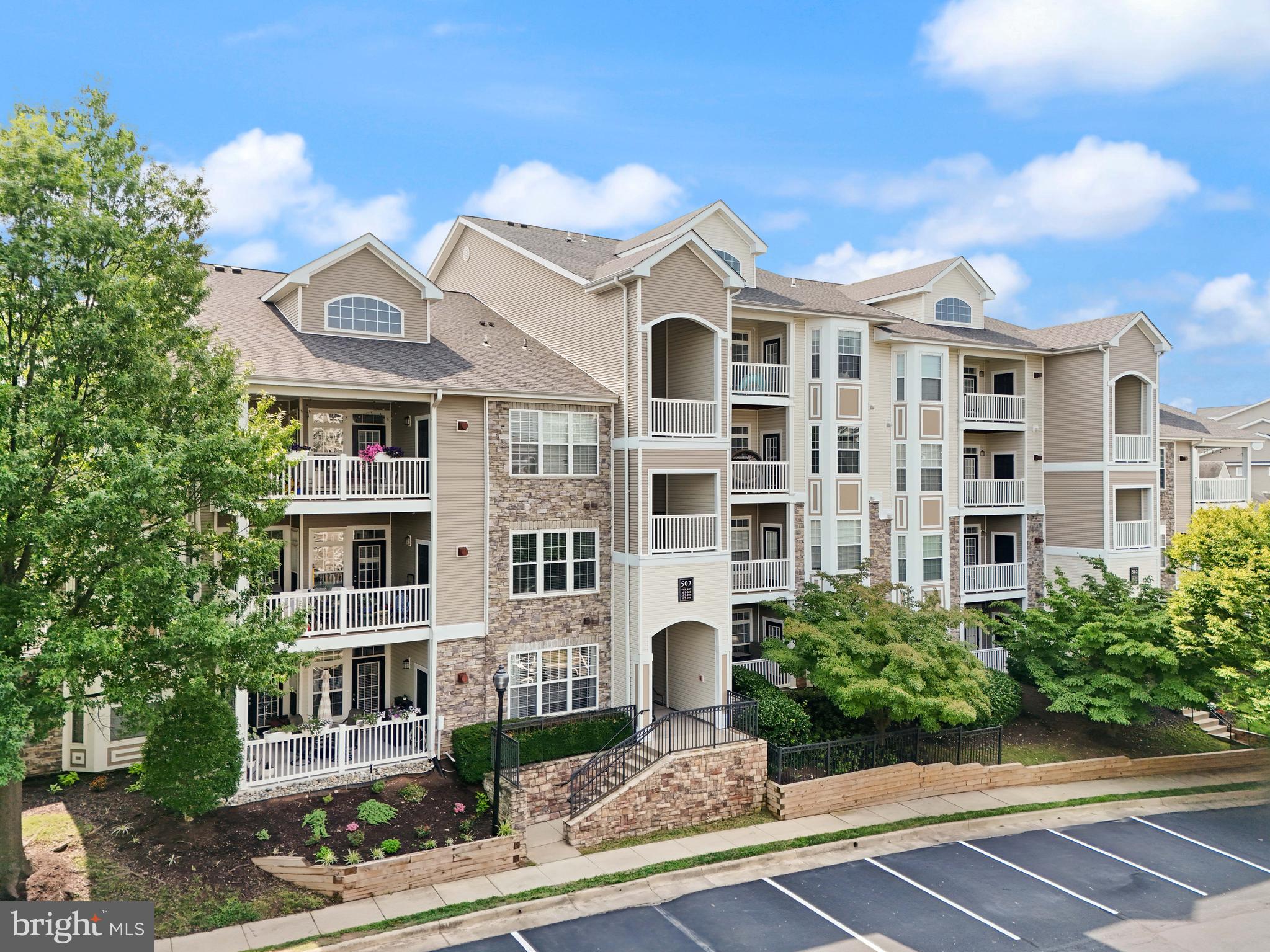 502 Sunset View Terrace Southeast, Unit 107 Leesburg, VA 20175 - Photo 5 of 50 a view of a white building among the street with palm trees