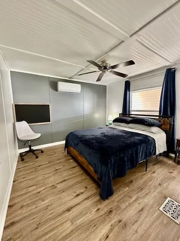 a bedroom with a bed and wooden floor