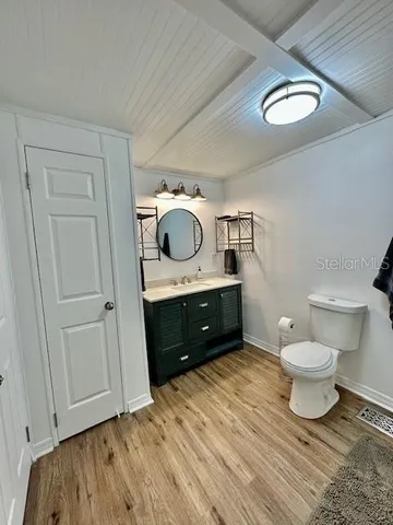 a bathroom with a toilet sink a mirror and vanity