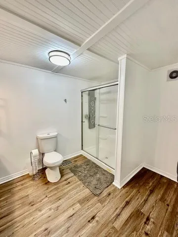 a view of a room with wooden floor and bench