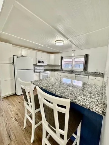 a kitchen with stainless steel appliances granite countertop a sink and a refrigerator